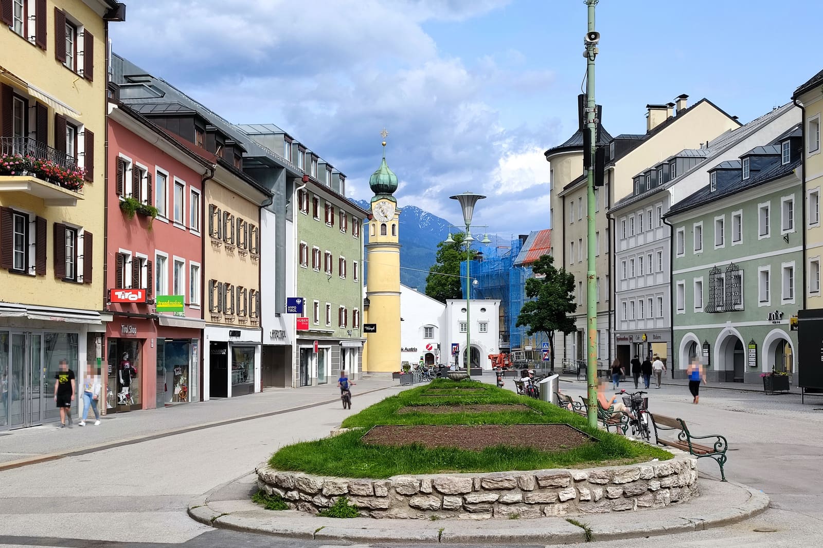 De Hauptplatz van Lienz met gekleurde gevels, terrassen en de bergen erachter.